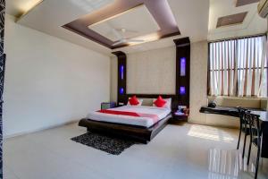 a bedroom with a bed with red pillows at Super OYO Hotel Neelam in Amrāvati
