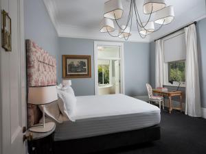 a bedroom with a bed and a desk and a lamp at Le Mas Barossa in Rowland Flat