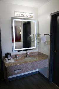 een badkamer met een wastafel en een grote spiegel bij Ramada by Wyndham Harrisonburg in Harrisonburg