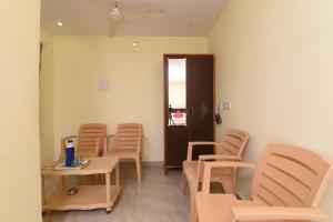 una sala de espera con sillas, una mesa y una puerta en OYO APHA Hotel, en Gunadala