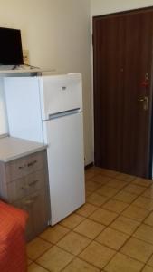 a white refrigerator in a room with a door at Monolocale Monticano in Motta di Livenza