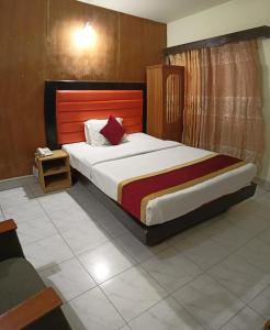 a bedroom with a large bed with a wooden headboard at Hotel Skylink in Dhaka