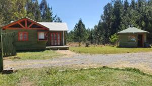 eine kleine Hütte in einem Hof neben einem Feld in der Unterkunft Cabañas Los Castaños Chovellén in Chovellén