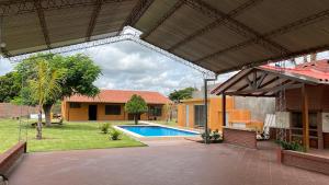 an outdoor patio with a pool and a building at Quinta Los Pinos Cotoca in Cotoca