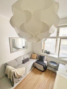uma sala de estar com um sofá e um lustre em Sweethome Studio 49 in City Center Punavuori district em Helsinque