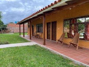 eine Terrasse mit zwei Stühlen an einem Haus in der Unterkunft Quinta Los Pinos Cotoca in Cotoca