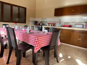 a kitchen with a table with a red and white checkered table cloth at Quinta Los Pinos Cotoca in Cotoca