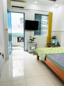 a bedroom with a bed and a flat screen tv at Homestay Ms. Hoa in Ho Chi Minh City