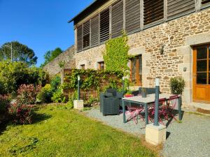 un giardino con tavolo e sedie di fronte a un edificio di Gite de la tannerie 3 a Dinan