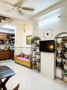 胡志明市的住宿－Homestay Ms. Hoa，客厅配有沙发和墙上的电视