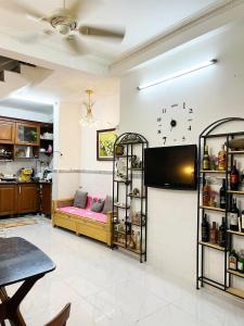 a living room with a couch and a tv on the wall at Homestay Ms. Hoa in Ho Chi Minh City