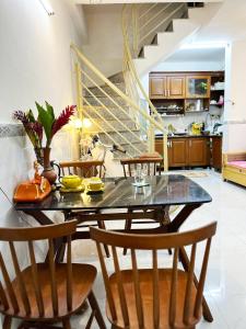 una cocina con mesa y sillas y una escalera en Homestay Ms. Hoa en Ho Chi Minh