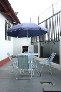 einen Tisch, Stühle und einen Regenschirm auf einer Terrasse in der Unterkunft Real Hostal in Guatemala