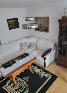 a living room with a white couch and a coffee table at Apartament Paradise in Międzyzdroje