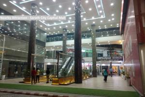 a shopping mall in a city with people walking in it at Capital O Hotel Green Leaf in Gachibowli