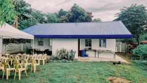 a house with chairs and a table and a blue roof at Beach House, San Juan, La Union in San Juan