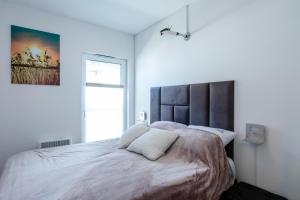 a bedroom with a large bed with a large headboard at Apartament Modern by Major Domus Club in Dziwnów