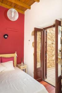 een slaapkamer met een bed en een rode muur bij Lovely mansion, in Piskokefalo - Crete, by Comfortbnb in Stavroménos