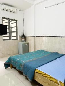 1 dormitorio con 1 cama con edredón azul en Homestay Ms. Hoa en Ho Chi Minh