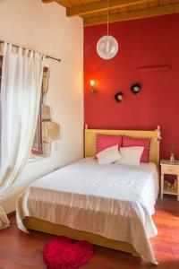 een slaapkamer met een bed met een rode muur bij Lovely mansion, in Piskokefalo - Crete, by Comfortbnb in Stavroménos