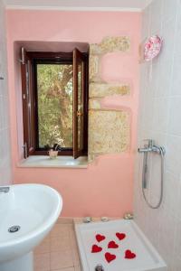 een roze badkamer met een wastafel en een raam bij Lovely mansion, in Piskokefalo - Crete, by Comfortbnb in Stavroménos