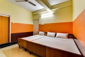 a large bed in a room with orange and white walls at OYO Srinivasa Residency Lodge in Tirupati
