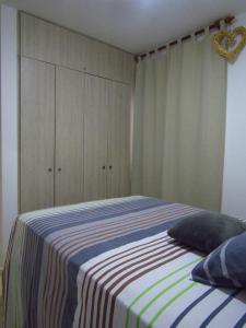 a bedroom with a bed with a striped blanket at hermoso apartamento amoblado in La Tebaida
