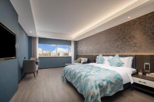 um quarto de hotel com uma cama grande e uma janela em Dijon Hotel Shanghai em Xangai