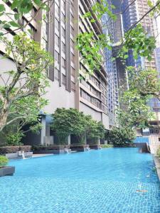 a large blue swimming pool in front of a building at 8 Kia Peng Suites Residence in Kuala Lumpur