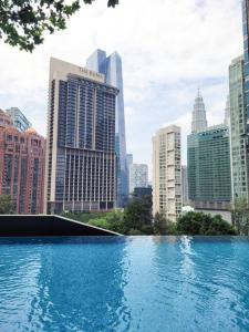 uma grande piscina de água numa cidade com edifícios altos em 8 Kia Peng Suites Residence em Kuala Lumpur