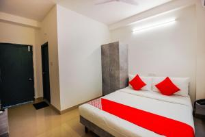 a bedroom with a bed with red pillows on it at D' Jade in Hyderabad