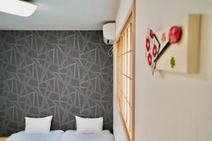duas camas num quarto com uma parede em Haku Tofukuji em Quioto