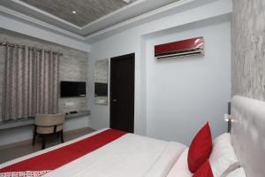 um quarto com uma cama, uma secretária e uma televisão em Flagship Hotel Mangalam Inn em Izatnagar