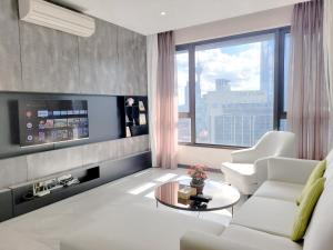 uma sala de estar com mobiliário branco e uma grande janela em 8 Kia Peng Suites Residence em Kuala Lumpur