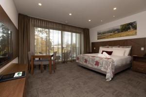 a hotel room with a bed and a desk and a television at Young Federation Motor Inn and Services Club in Young +58 photos