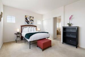 ein Schlafzimmer mit einem großen Bett und einem roten Stuhl in der Unterkunft Nancy Homes - Private Rooms with private or shared bathroom and shared kitchen near Kaiser SFO in Daly City