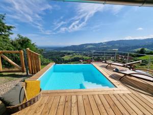 a pool on a deck with a view of the mountains at Weinstöckl Hochgrail pures sein in Sankt Stefan ob Stainz