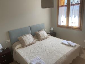 a bedroom with a bed with white sheets and a mirror at Apartamento Casa Francho 3 in Panticosa