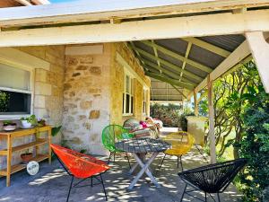 d'un patio avec des chaises colorées et une table. dans l'établissement Spacious Holiday Home-Ramco, à Waikerie