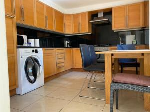 a kitchen with a washing machine and a table with chairs at Terraced House near the Sea in Livorno