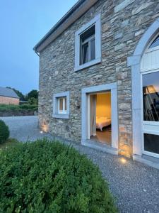 a stone house with a window with a bed in it at La chambre d’auguste in Saint-Hubert