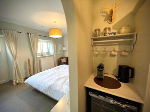 a bathroom with a bed and a sink in a room at La chambre d’auguste in Saint-Hubert