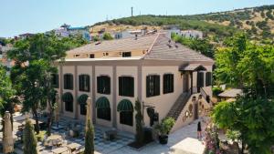 an aerial view of a house with a hill in the background at BİADA OTELLERİ in Bozcaada