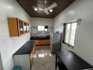 a kitchen with a stainless steel refrigerator and cabinets at Saagvan Villa in Pune