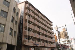 名古屋的住宿－HOTEL LiVEMAX BUDGET Nagoya，一座高大的建筑,旁边是箱子