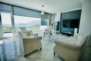 Una sala de estar con muebles blancos y una gran ventana. en VİLLA ÇAPA, en Kas