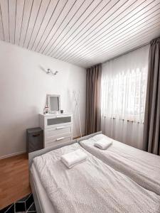 a bedroom with a bed with two white towels on it at Summer House in Lubniewice