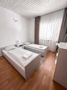 a white bedroom with a bed and a couch at Summer House in Lubniewice