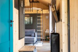 a room with a couch and a chair in a tiny house at ChillZone-Hill Domki z balią in Szalejów Górny