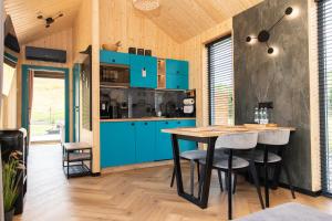 a kitchen with blue cabinets and a table at ChillZone-Hill Domki z balią in Szalejów Górny